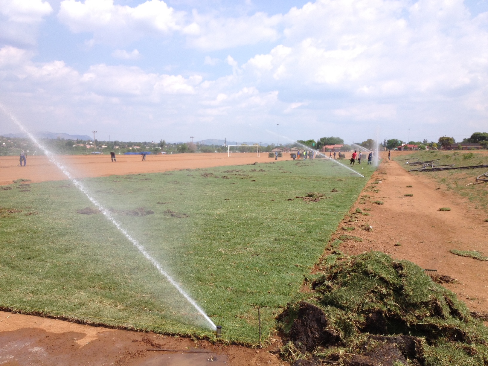 A fire hydrant spewing water onto a field