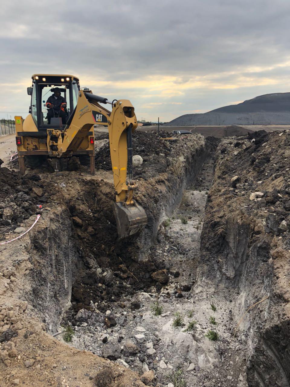 A bulldozer digging through a large hole in the ground